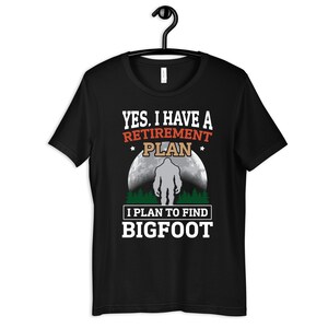 May include: Black t-shirt with a graphic of a Bigfoot silhouette in front of a full moon. The text reads "Yes, I have a retirement plan. I plan to find Bigfoot."