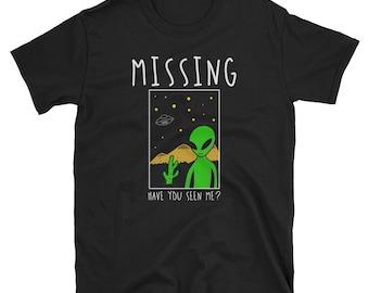 May include: Black t-shirt with a white graphic of an alien standing in a desert landscape with the text "MISSING" and "HAVE YOU SEEN ME?"