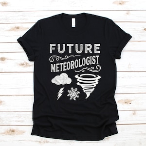 Puede incluir: Camiseta negra con texto blanco que dice "Future Meteorologist" con un gráfico de nube, rayo, copo de nieve y tornado.