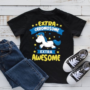 Pode incluir: Camiseta preta com um unicórnio branco e o texto "EXTRA CHROMOSOME EXTRA AWESOME" em letras amarelas e azuis.