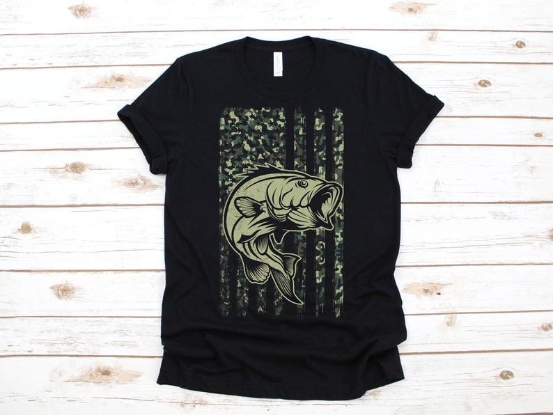 May include: Black t-shirt with a camouflage American flag design featuring a bass fish jumping out of the water.
