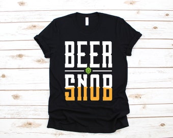Puede incluir: Camiseta negra con texto blanco que dice "Beer Snob" con un gráfico de lúpulo verde sobre la palabra "Snob".