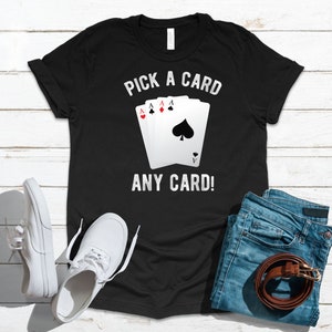 May include: Black t-shirt with white text that says "Pick a card, any card!" and a graphic of playing cards.