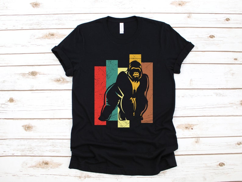 May include: Black t-shirt with a vintage-style graphic of a gorilla in front of a colorful striped background.