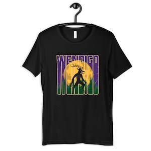 Pode incluir: Camiseta preta com uma estampa gráfica de uma criatura Wendigo em pé na frente de uma lua cheia. A criatura é uma figura humanoide com chifres e um corpo longo e magro. A lua é amarela e o fundo é roxo com árvores verdes.