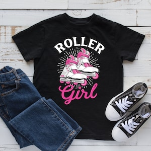 Puede incluir: Camiseta negra con el texto "Roller Girl" en letras rosa y blancas. El diseño presenta un par de patines rosas y blancos sobre un fondo blanco.