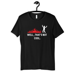 Może przedstawiać: Czarny T-shirt z białą postacią ludzką skaczącą nad płomieniami i tekstem "WELL, THAT'S NOT COOL."