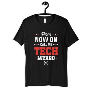 Puede incluir: Camiseta negra con texto blanco que dice "From now on call me Tech Wizard". El texto está en negrita con acentos rojos. Un símbolo blanco está debajo del texto.