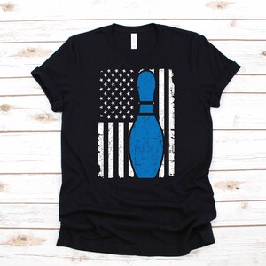 May include: A black t-shirt with a distressed American flag design and a blue bowling pin in the center.