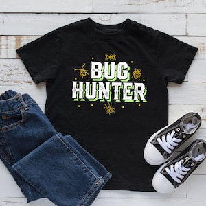 May include: Black t-shirt with a green and white graphic that says "Bug Hunter" with small bug illustrations around the text.