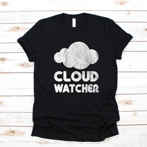 May include: Black t-shirt with a white cloud graphic and the text "CLOUD WATCHER" printed on the front.
