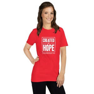 May include: Red short-sleeved t-shirt with white text that reads "CREATED for HOPE" in a box with the website "createdforhope.com" below.