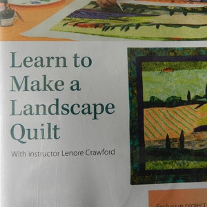 Könnte beinhalten: Ein Buchcover mit dem Titel "Lernen Sie, eine Landschaftsdecke zu nähen" und einem Bild einer Landschaftsdecke in Grün-, Braun- und Blautönen. Der Text "Mit Anleitung von Lenore Crawford" befindet sich unter dem Titel.