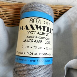 Könnte beinhalten: Ein grauer Ball 8071 5-fädiger Maxwell 100% Acryl-Macrame-Schnur für Innen- und Außenbereich. Das Etikett lautet "210 ft. 70 yds. 63.98 m. Colorfast Fade Resistant Non To. Lake Shore Dr. Suite 510A Chicago, IL"