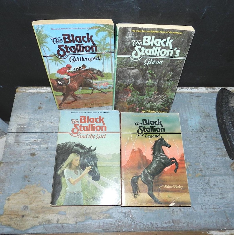May include: Four vintage paperback books from "The Black Stallion" series by Walter Farley. The covers feature illustrations of horses, a jockey, and a girl with a horse. Titles include "Challenged!", "Ghost", "and the Girl", and "Legend".