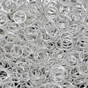Puede incluir: Un montón de pequeños anillos de salto plateados y brillantes. Estos anillos de metal abiertos se utilizan para la fabricación de joyas y otras manualidades. Los anillos son redondos y tienen una superficie brillante y reflectante.