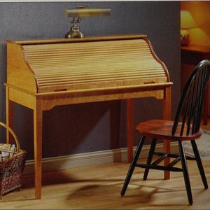 May include: A wooden roll top desk with a black chair. The desk has a light wood finish and a roll top lid. The chair has a black wooden frame and a brown seat.