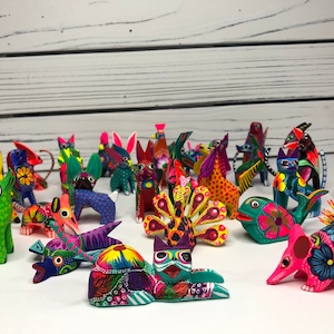 May include: A collection of colorful, hand-painted wooden animal figurines. The figurines are all different shapes and sizes, and they are painted in bright, vibrant colors. Some of the animals include a cat, a dog, a bird, a fish, and a turtle.