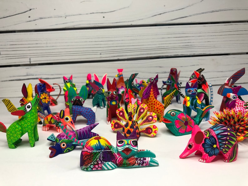May include: A collection of colorful, hand-painted wooden animal figurines. The figurines are all different shapes and sizes, and they are painted in bright, vibrant colors. Some of the animals include a cat, a dog, a bird, a fish, and a turtle.
