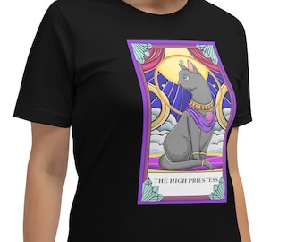 Puede incluir: Camiseta negra con un gráfico de una carta de tarot que presenta un gato gris con una túnica morada y una corona. La carta se titula "La Sacerdotisa".