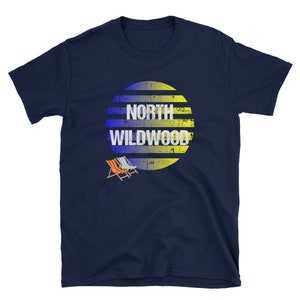 Puede incluir: Camiseta azul marino con un gr&aacute;fico de sol a rayas amarillas y azules. El gr&aacute;fico del sol tiene el texto "NORTH WILDWOOD" en blanco.