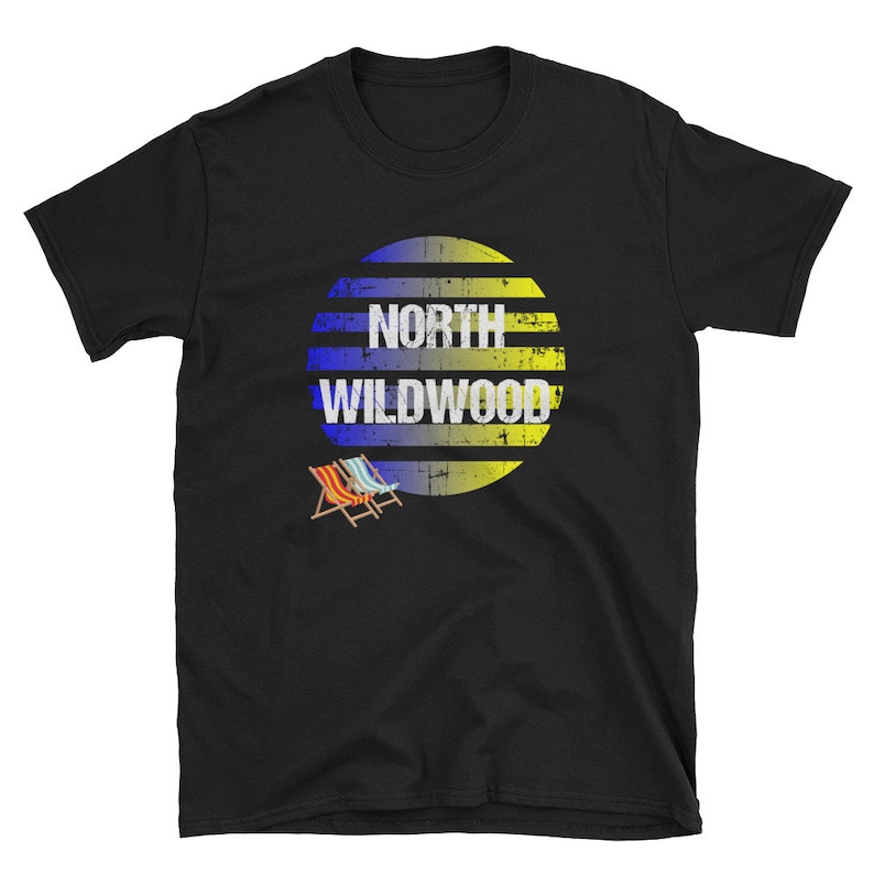 Puede incluir: Camiseta negra con un c&iacute;rculo gr&aacute;fico de rayas amarillas y azules que dice "North Wildwood". Hay dos sillas de playa en la esquina inferior izquierda del dise&ntilde;o.