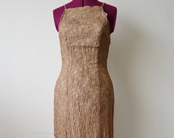 May include: A long, brown lace dress with a halter neckline. The dress is sleeveless and has a fitted silhouette.