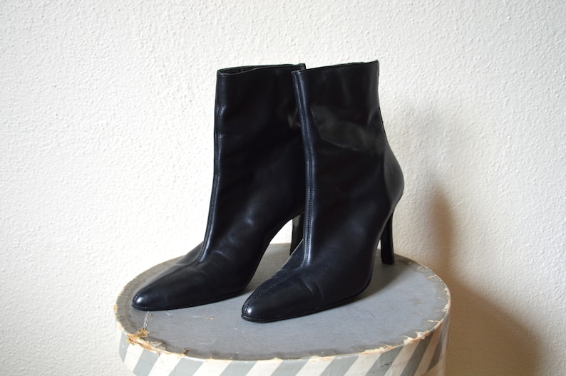May include: A pair of black leather ankle boots with stiletto heels.