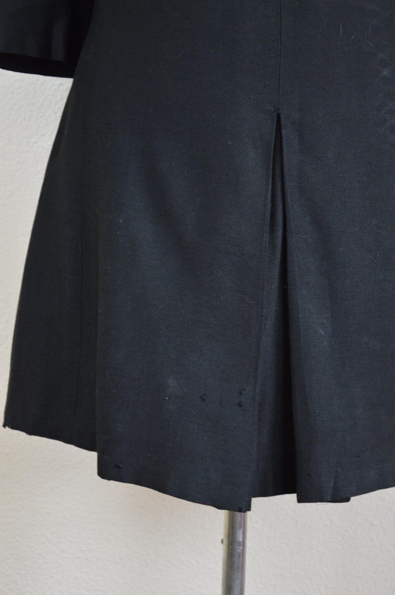 May include: Black knee-length dress with a single back vent and a straight skirt.