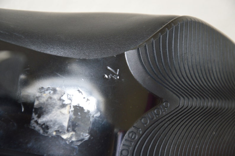 May include: Close-up of the bottom of a black shoe with a textured sole. The sole has the word "DURO" printed on it.