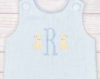 May include: Blue and white striped baby overalls with a blue embroidered letter "R" and two yellow embroidered dogs on the front.
