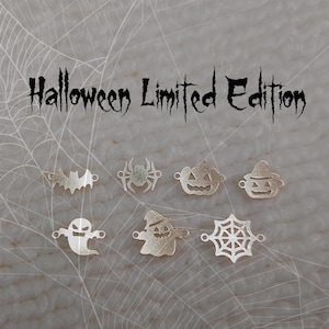 May include: Silver Halloween charms in the shapes of a bat, spider, pumpkin, ghost, and spiderweb. The text "Halloween Limited Edition" is above the charms in a spooky font. The background has a spiderweb design.