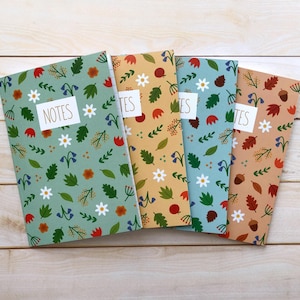 May include: Four different patterned notebooks with the word "NOTES" on the front of the first notebook. The notebooks have a floral and leaf pattern in shades of green, blue, orange, and brown.