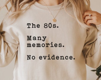 May include: A beige sweatshirt with the text "The 80s. Many memories. No evidence." printed in black.