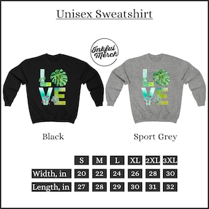 May include: Unisex sweatshirt with a graphic of the word "LOVE" with tropical leaves and flowers. The sweatshirt is available in black and sport grey. The size chart shows the width and length in inches for sizes S through 3XL.