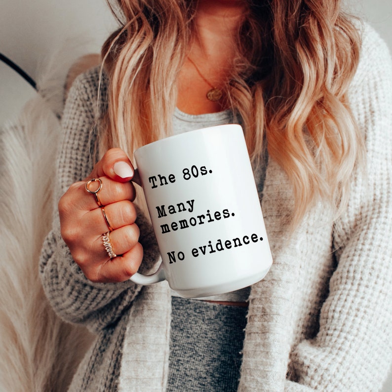 May include: White ceramic mug with black text that reads "The 80s. Many memories. No evidence."