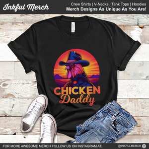 May include: Black t-shirt with a retro-style graphic of a rooster wearing a cowboy hat and the text "CHICKEN Daddy".