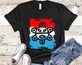 May include: Black t-shirt featuring a colorful graphic design. The design includes a red, white, and blue background with a unique black and white symbol. The shirt is paired with blue jeans and white sneakers. The text "Inkful Merch" is at the top.