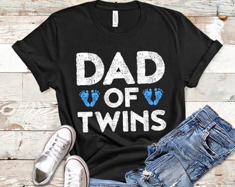 Könnte beinhalten: Schwarzes T-Shirt mit weißem Text, der "DAD OF TWINS" lautet, mit zwei blauen Baby-Fußabdrücken über dem Wort "OF".
