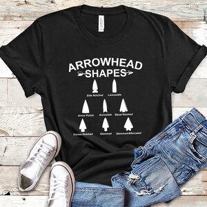 May include: Black t-shirt with a white graphic of different arrowhead shapes and their names. The text reads "Arrowhead Shapes".