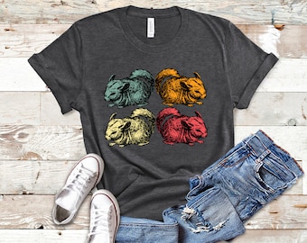 May include: A dark gray t-shirt with a retro-style design featuring four chinchillas in different colors: green, yellow, red, and orange. The chinchillas are drawn in a vintage style with a simple outline.