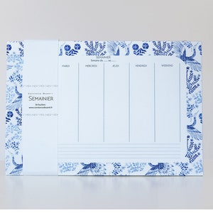 Peut inclure: Un planificateur hebdomadaire blanc avec une bordure florale bleue. Le planificateur comporte des sections pour chaque jour de la semaine, y compris lundi, mardi, mercredi, jeudi, vendredi, samedi et dimanche. Le planificateur comporte également une section pour le week-end. Le planificateur est décoré d'un motif floral bleu et le texte "SEMAINIER" est imprimé en haut.