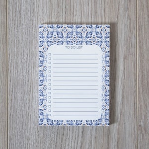 Könnte beinhalten: Ein weißer Notizblock mit einem blauen und weißen gemusterten Rand. Der Notizblock hat eine Überschrift "To do list" und einen linierten Bereich zum Schreiben.