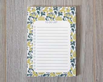 May include: A white notepad with a floral border in shades of yellow and green. The notepad has a lined section with the words "TO DO LIST" at the top.