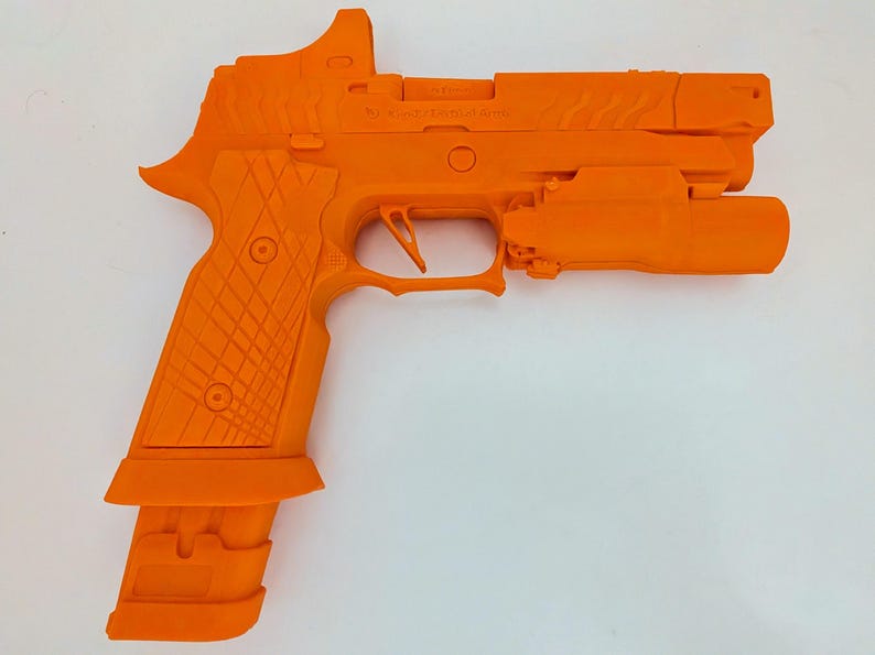 May include: Bright orange handgun with a mounted light and sight. The grip has a textured pattern, and the magazine is extended. The gun is a solid, single color, and appears to be a training or display model.