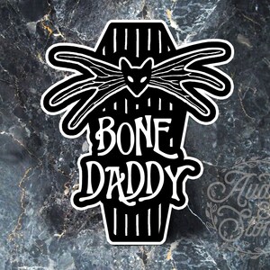 May include: Black and white sticker design featuring a coffin with a bat inside and the text "BONE DADDY".