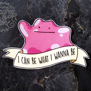 May include: Pink cartoon character with white spots and a banner that reads "I can be what I wanna be".