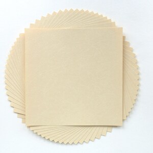 Puede incluir: Una pila de hojas de papel de color crema en forma de abanico en un círculo, creando una forma circular.