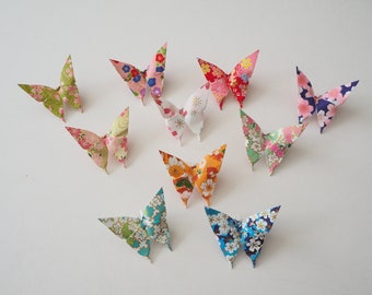May include: Ten origami butterflies made of colorful patterned paper. The butterflies are arranged in a semi-circle on a white background.