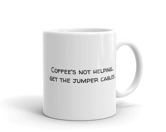 May include: White ceramic coffee mug with black text that reads "COFFEE'S NOT HELPING... GET THE JUMPER CABLES."